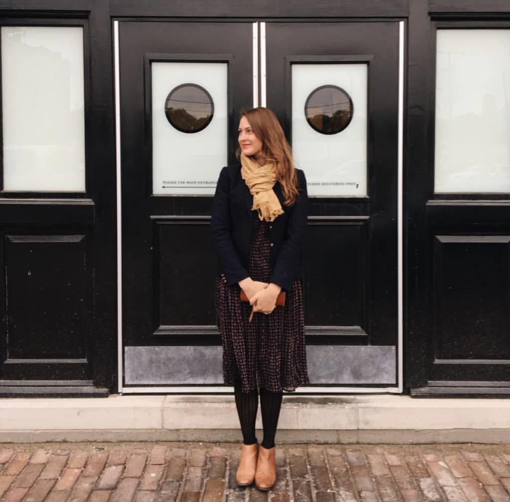 woman standing in front of doors with hands clasped